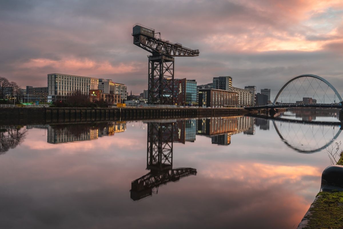Finnieston Crane and the Squinty Bridge reflected in the River Clyde at sunset in Glasgow
